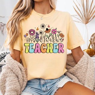 Woman wearing butter Comfort Colors tee with colorful TEACHER bubble letters and wildflower butterfly design
